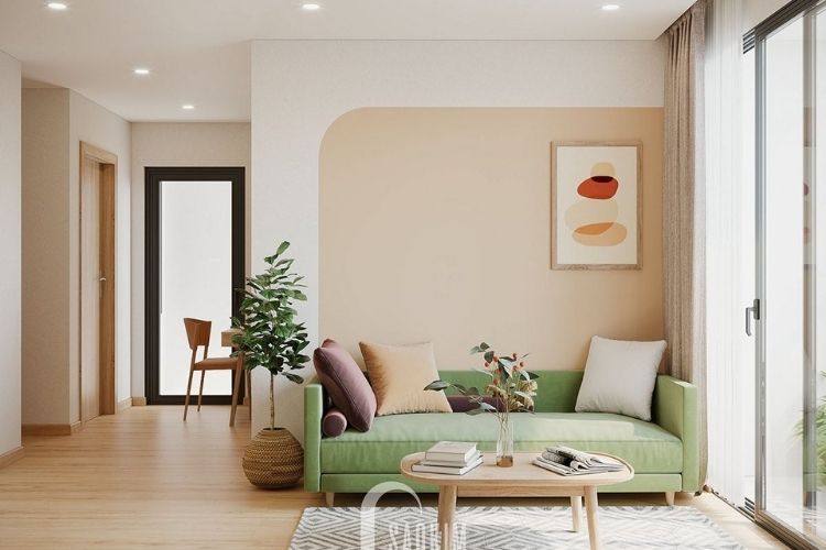 Pasztell barack árnyalatú falfestékkel festett nappali fal zöld kanapéval, meleg tónusú, harmonikus enteriőrben